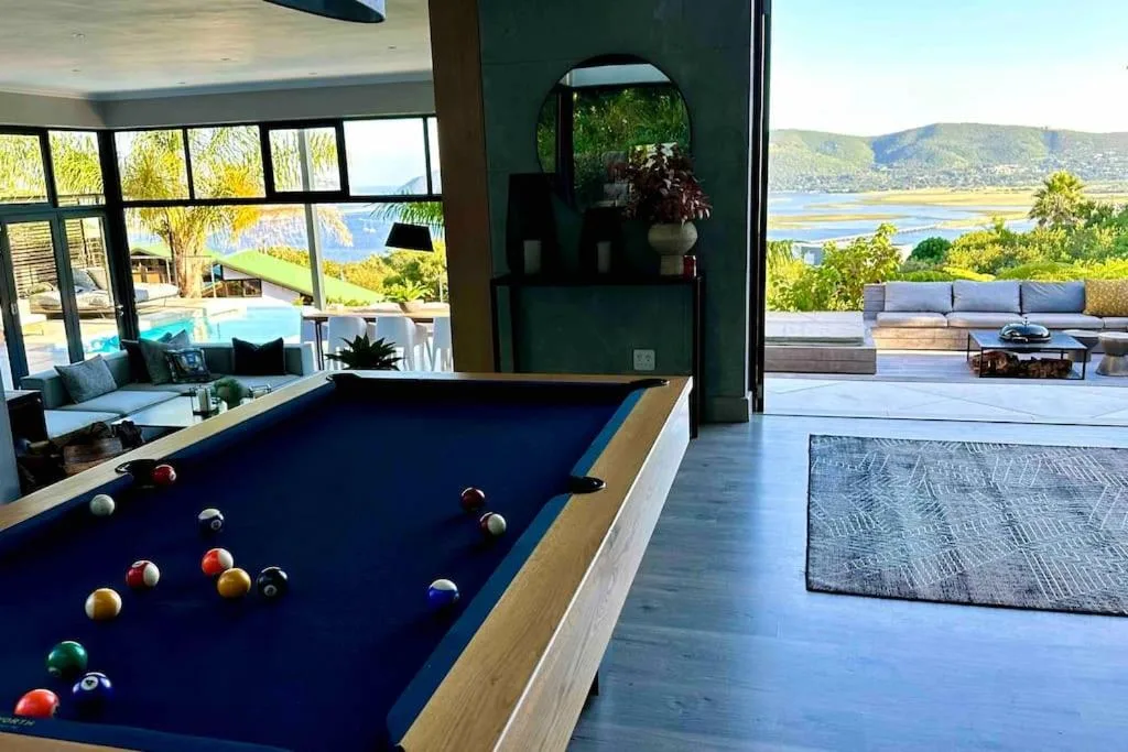 Open-plan lounge with pool table, lagoon views, and outdoor deck access