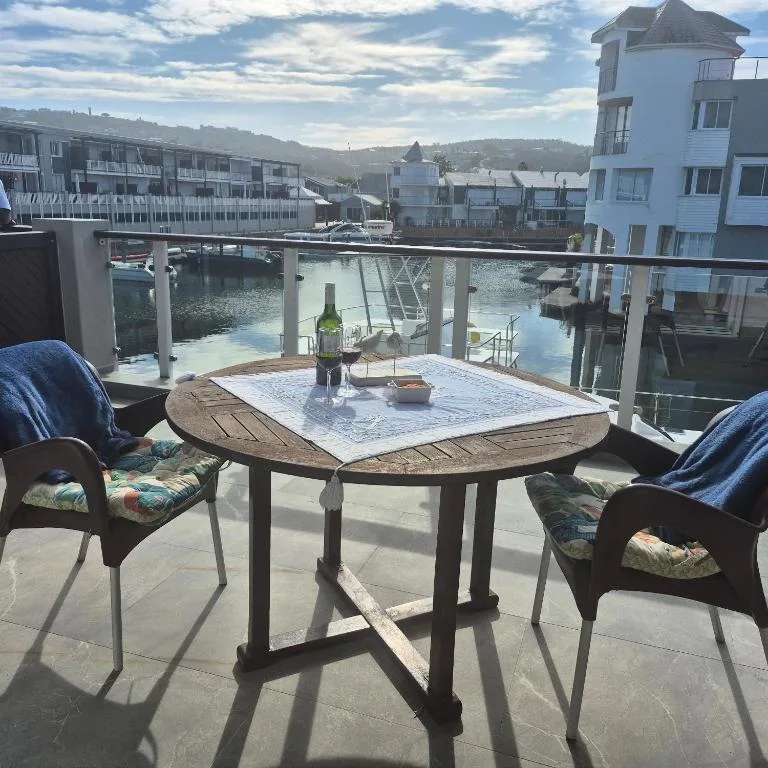 Waterfront deck with dining table and chairs overlooking Knysna lagoon