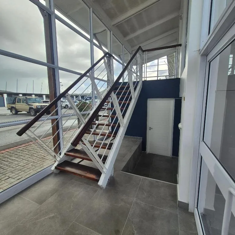 Modern waterfront entrance with metal staircase and harbor views