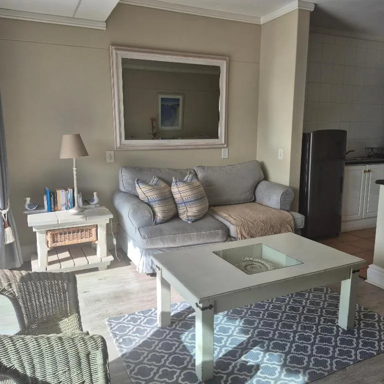 Bright living room with gray sofa, white coffee table, and framed mirror