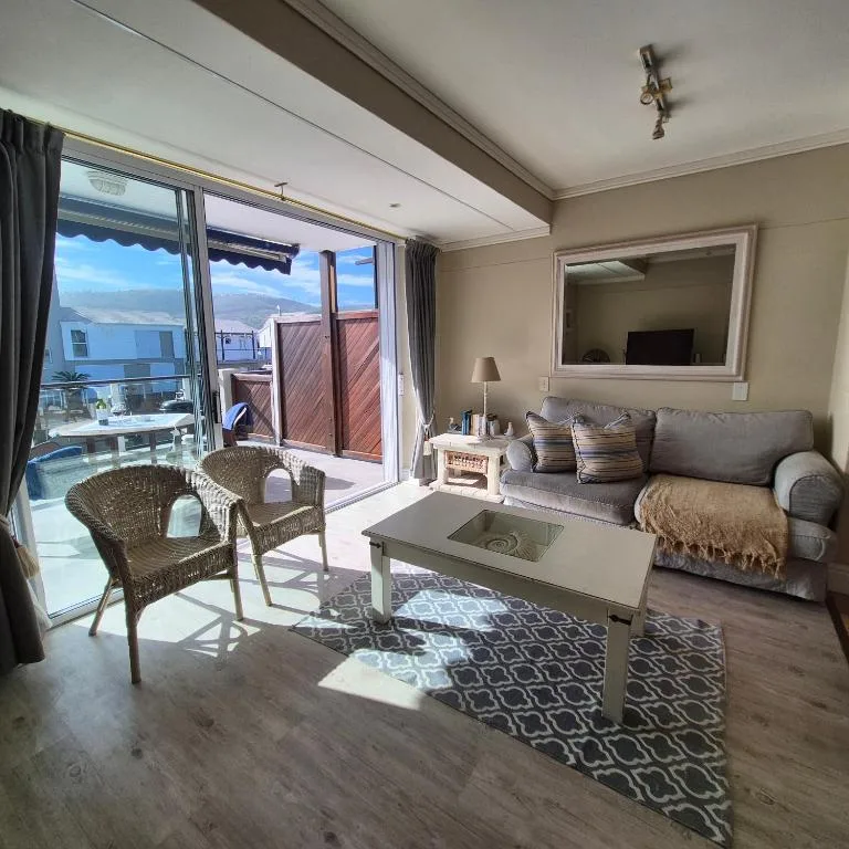 Modern lounge with sofa, coffee table, and ocean views through sliding doors
