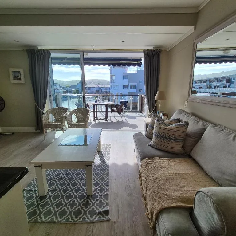 Spacious lounge with sofa, coffee table, and mountain views through large windows