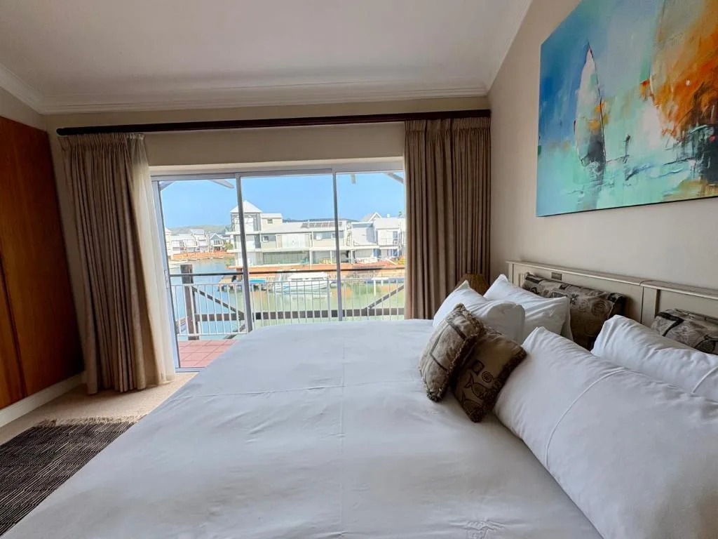 Spacious bedroom with waterfront view through sliding glass doors