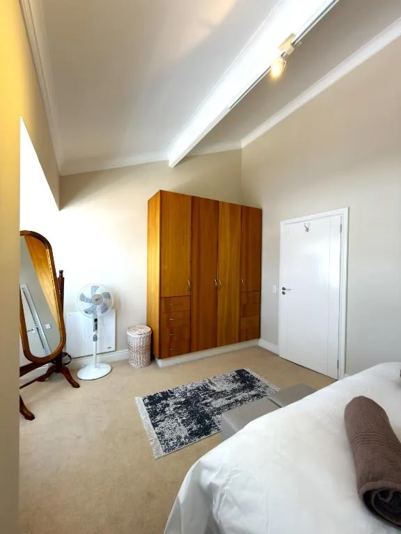 Bright bedroom with wooden wardrobe, skylight, and modern amenities