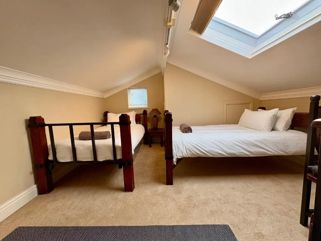 Spacious bedroom with two beds and skylights overhead