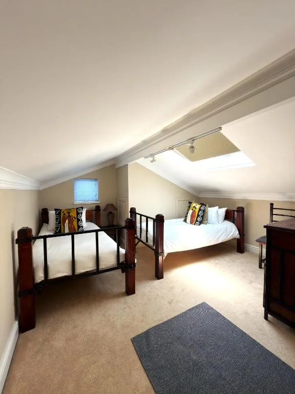 Bright attic bedroom with two beds and skylight window