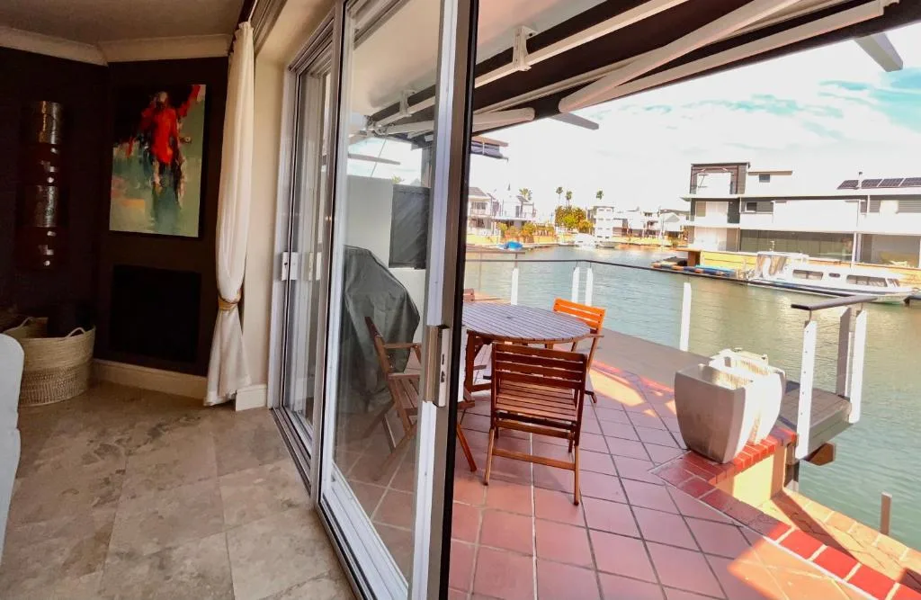Waterfront deck with wooden chairs overlooking Knysna lagoon and moored boats