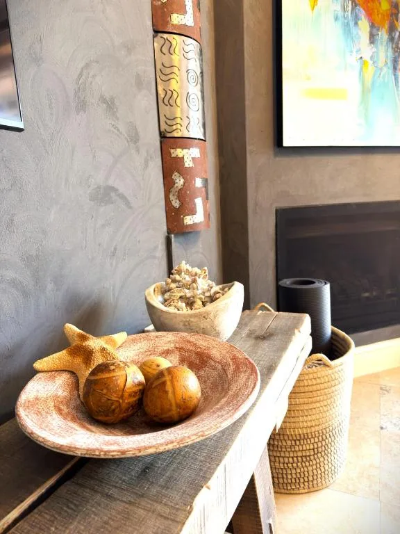 Decorative wooden bowls with fruit and artwork on shelf