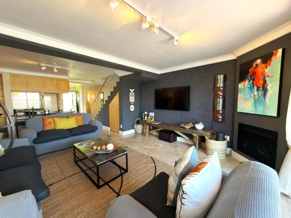 Modern living room with blue sofa, fireplace, and wall-mounted television