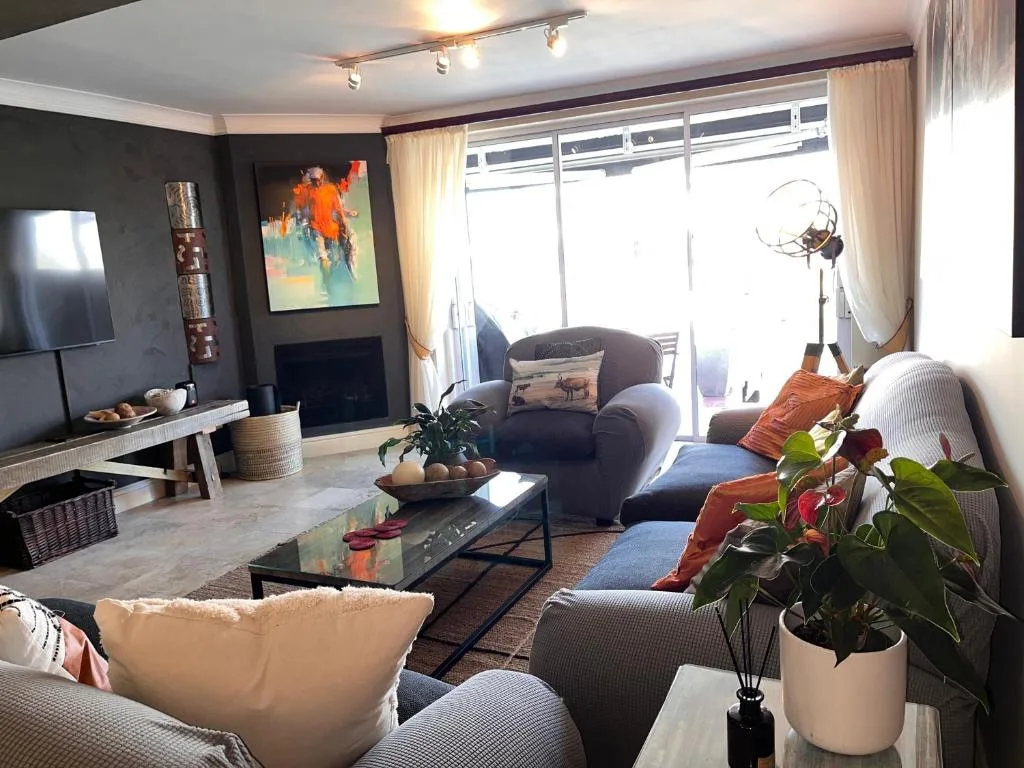Modern lounge with comfortable seating, fireplace, and large windows overlooking water