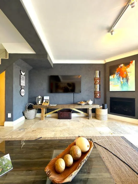 Modern lounge with wall-mounted TV, fireplace, and contemporary decor