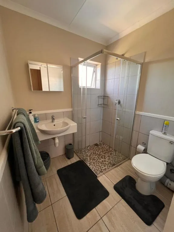 Modern bathroom with shower cubicle, vanity sink, and toilet facilities
