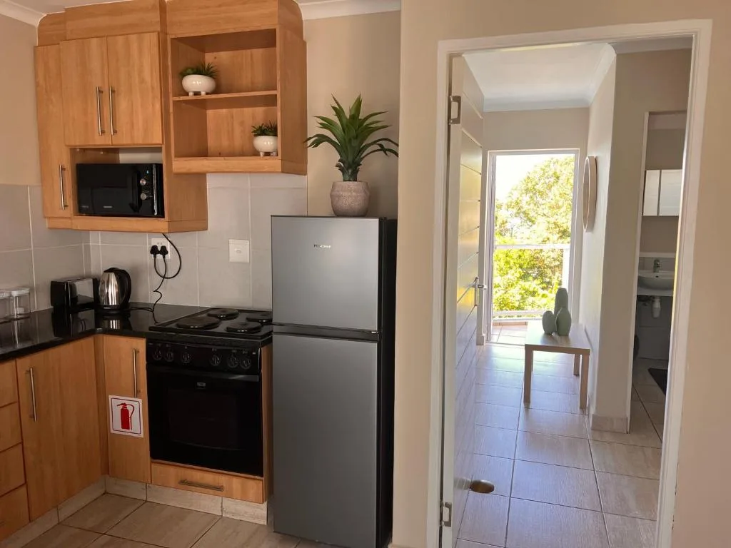 Modern kitchen with wooden cabinetry, stainless steel appliances, and microwave