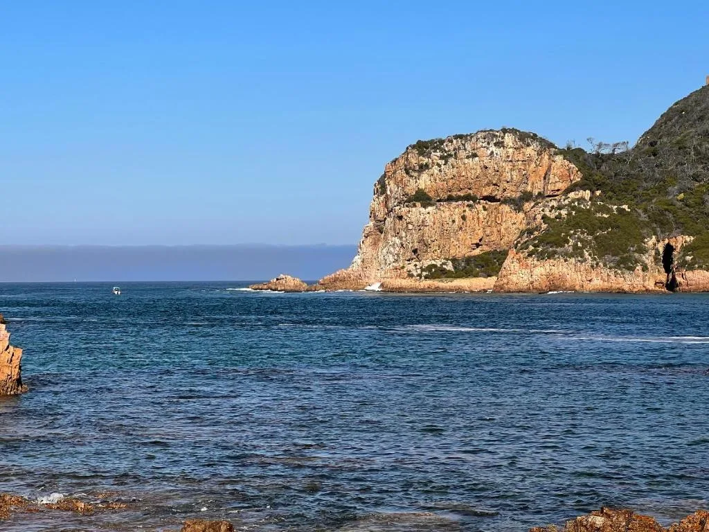 Rocky coastal headland with turquoise waters under clear blue sky