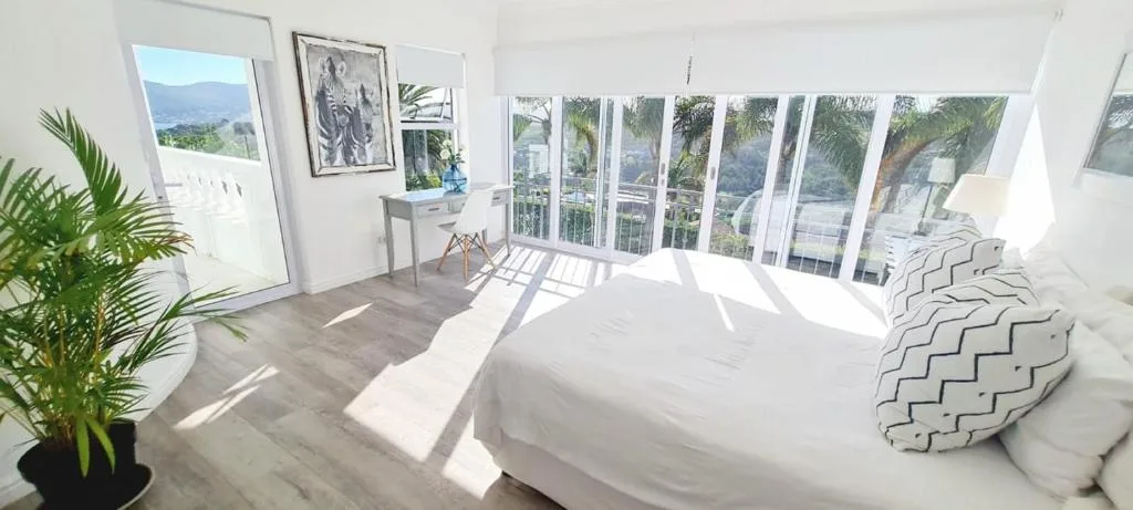 Bright bedroom with king bed, mountain views, and glass doors to deck
