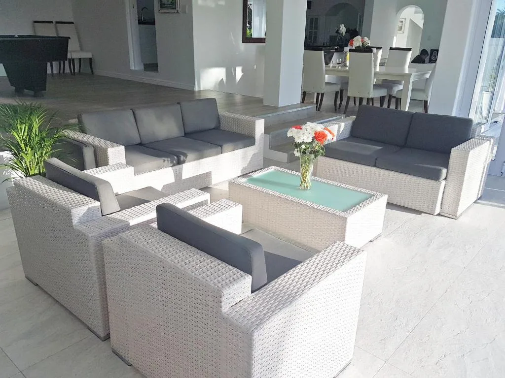 Spacious outdoor lounge area with wicker furniture and grey cushions