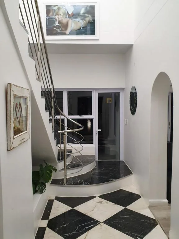 Modern interior hallway with geometric marble flooring and spiral staircase