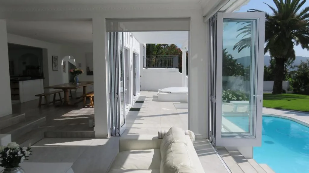 Bright modern lounge with sliding doors opening to pool and garden views