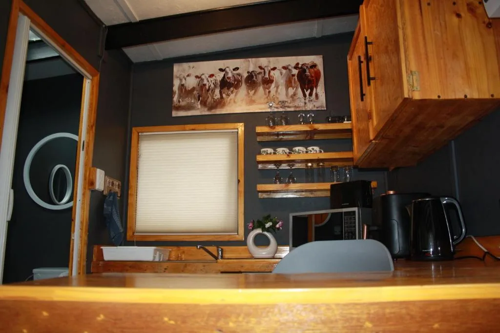 Modern kitchen with wooden cabinetry, open shelving, and black accent walls