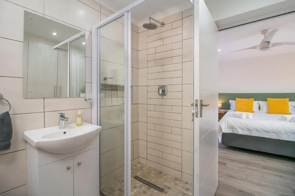 Modern bathroom with vanity sink, large mirror, and walk-in shower enclosure