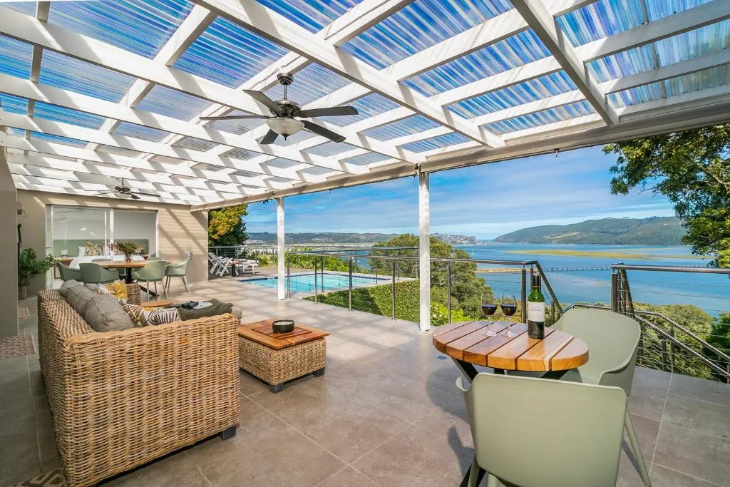 Covered deck with lounge seating, ocean views, and pool access