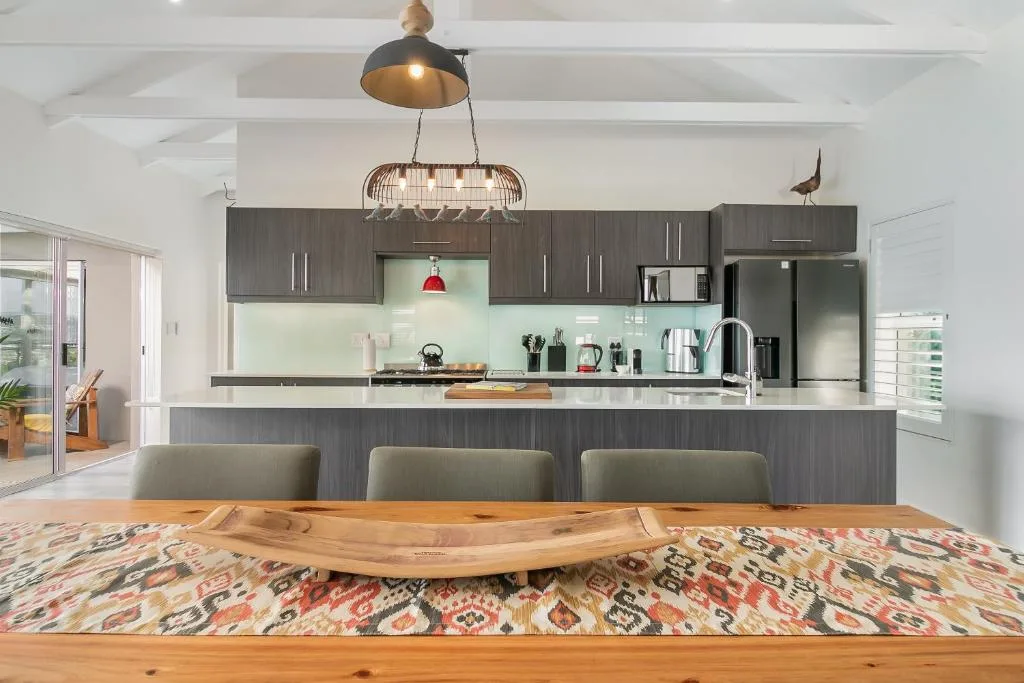 Modern open-plan kitchen with gray cabinetry, white countertops, and pendant lighting