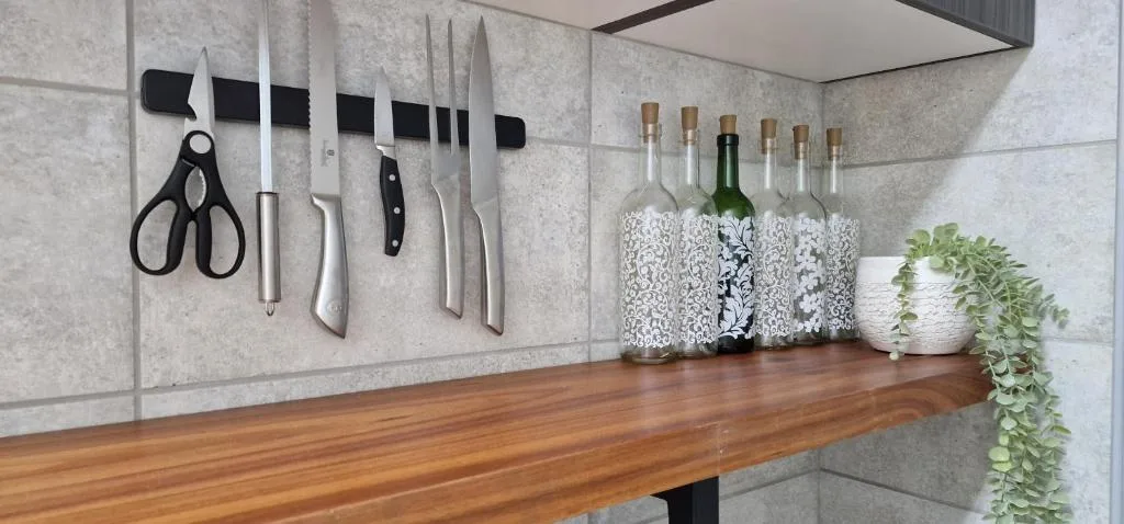 Modern kitchen counter with knife magnetic strip and decorative bottles
