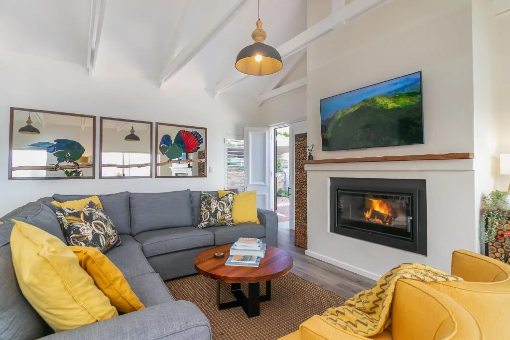 Spacious living room with gray sectional, fireplace, and yellow accent chairs