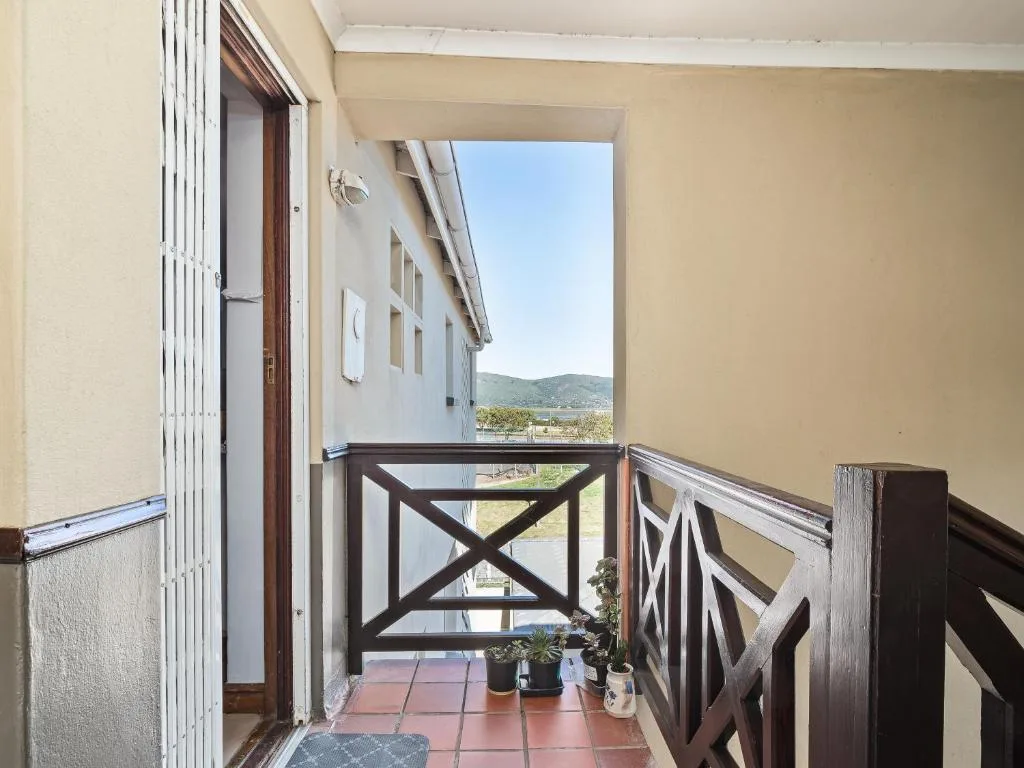Wooden-railed balcony with terracotta tiles overlooking mountain landscape