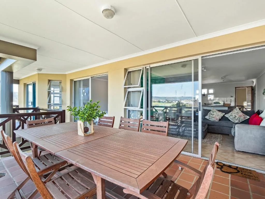Spacious outdoor deck with dining table overlooking mountain landscape views