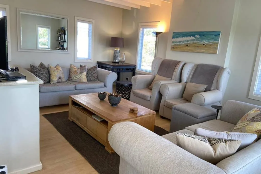 Spacious living room with comfortable seating and ocean artwork on walls