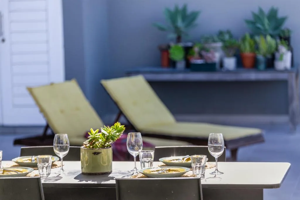 Outdoor dining setup with place settings and lounge chairs on modern patio