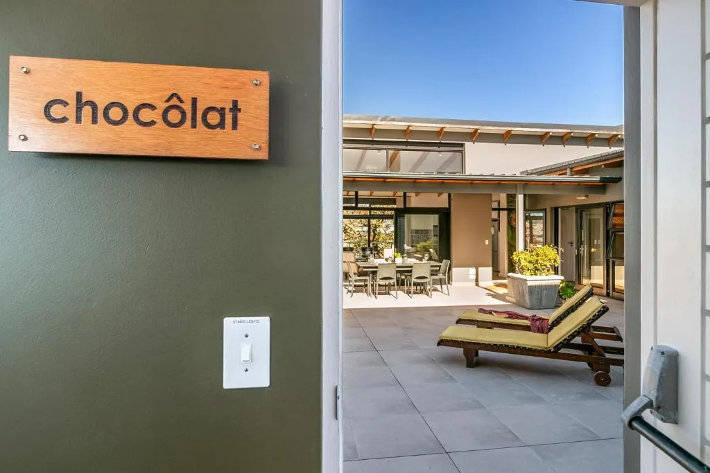 Modern patio with loungers, dining area, and clear skies overhead
