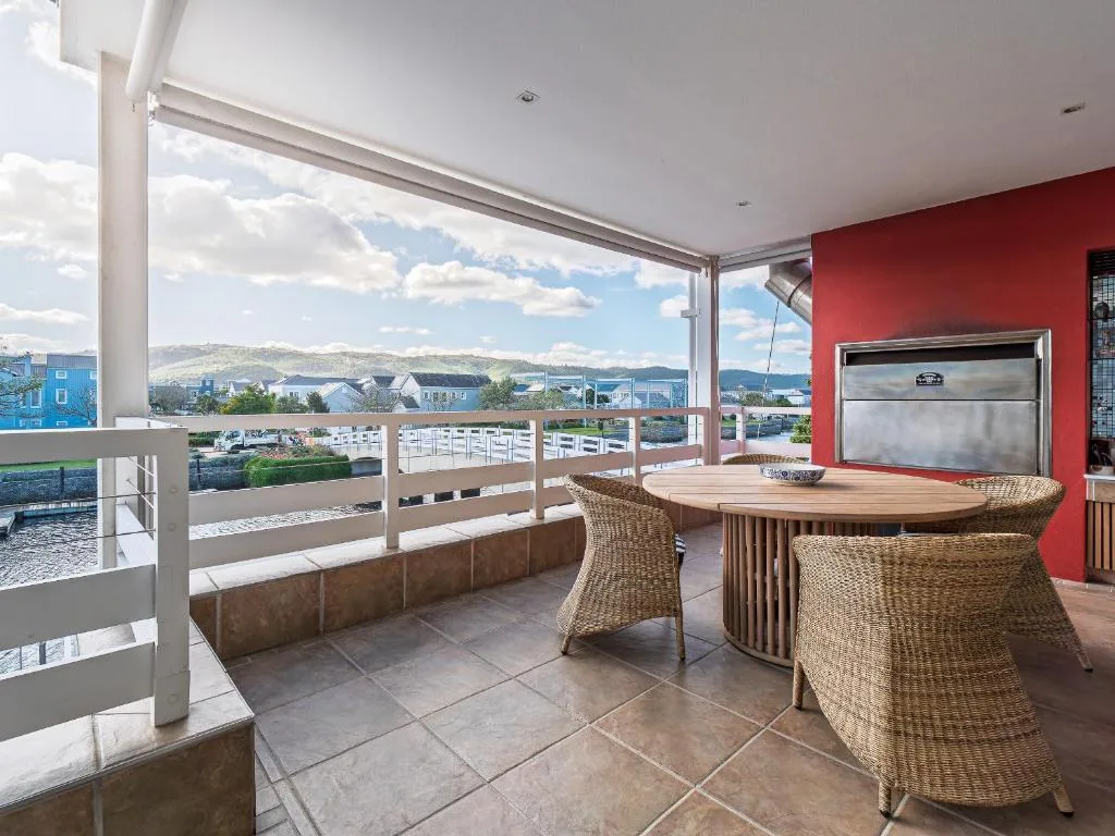 Waterfront deck with wicker seating and scenic lagoon views