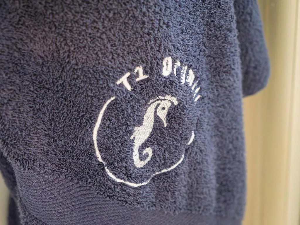 Close-up of embroidered seahorse logo on navy towel