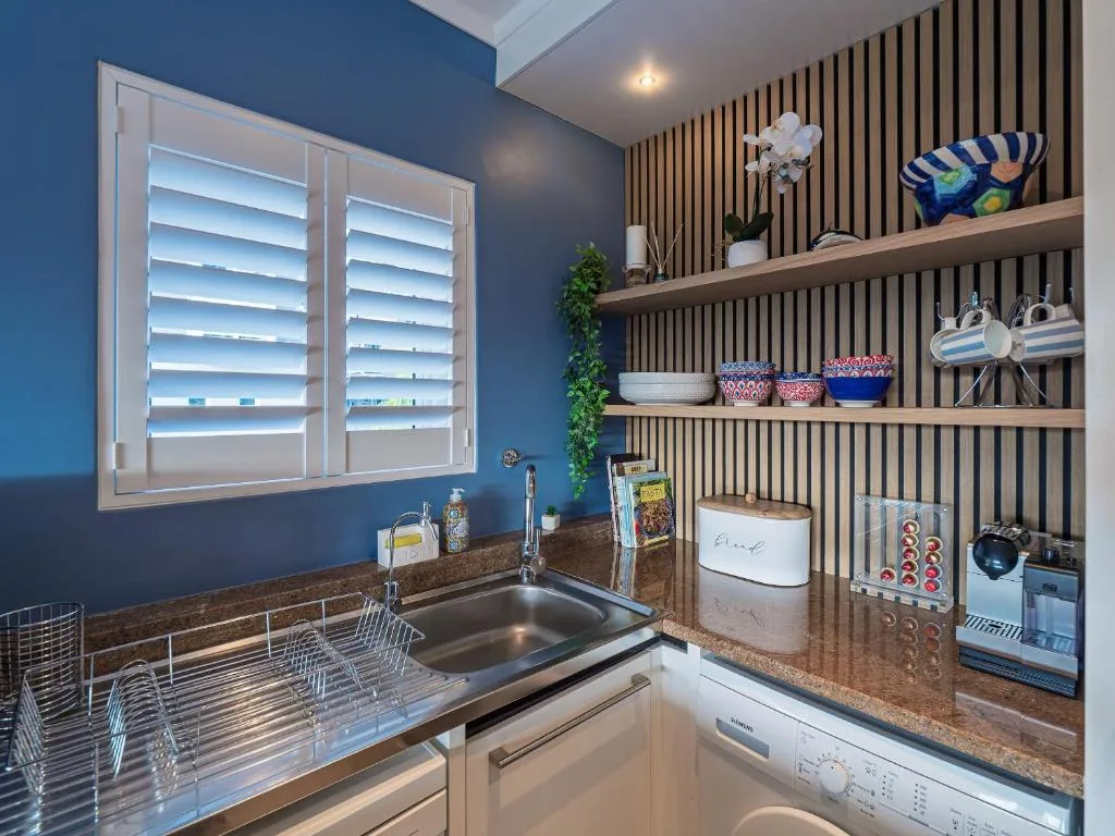 Modern kitchen with sink, stove, and organized wooden shelving unit