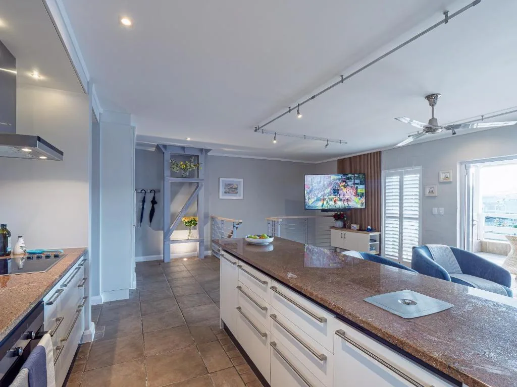 Modern kitchen with white cabinetry, granite countertops, and island seating