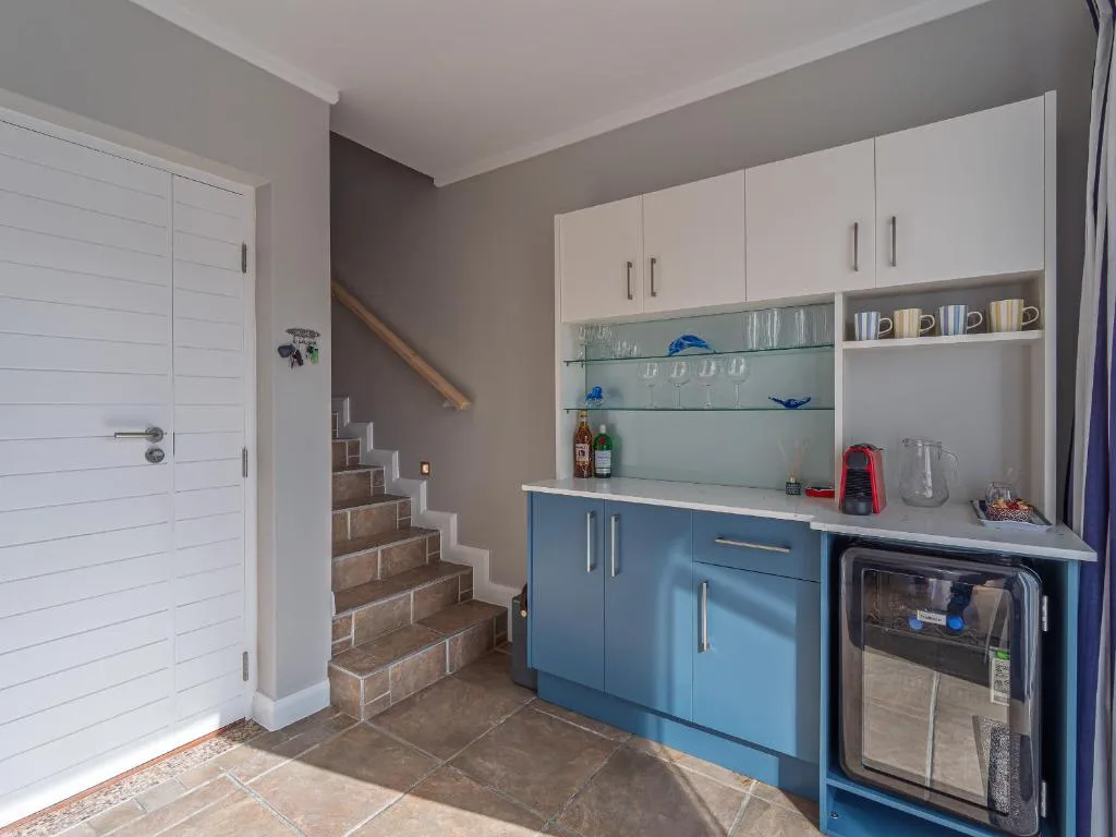 Modern kitchen with blue cabinetry, white upper cabinets, and stainless steel appliances