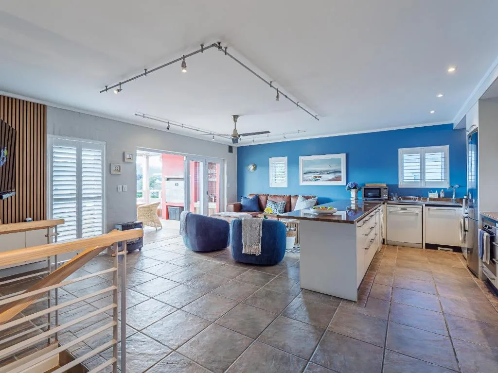 Open-plan lounge with bright blue accent wall and comfortable seating