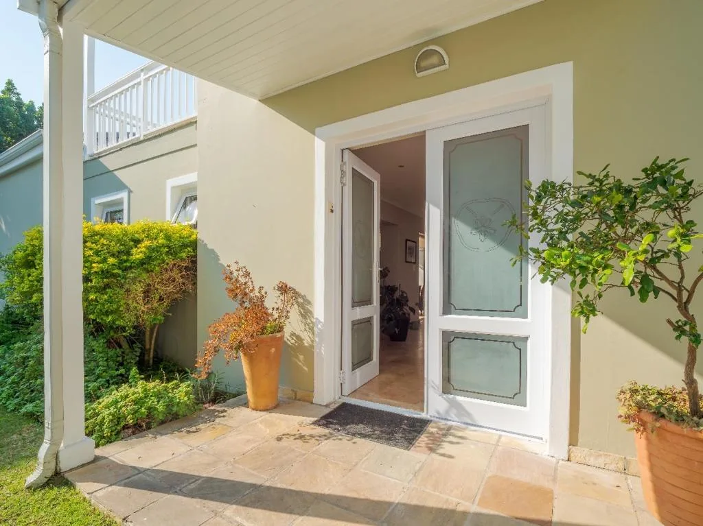 Covered patio with potted plants and French doors leading indoors