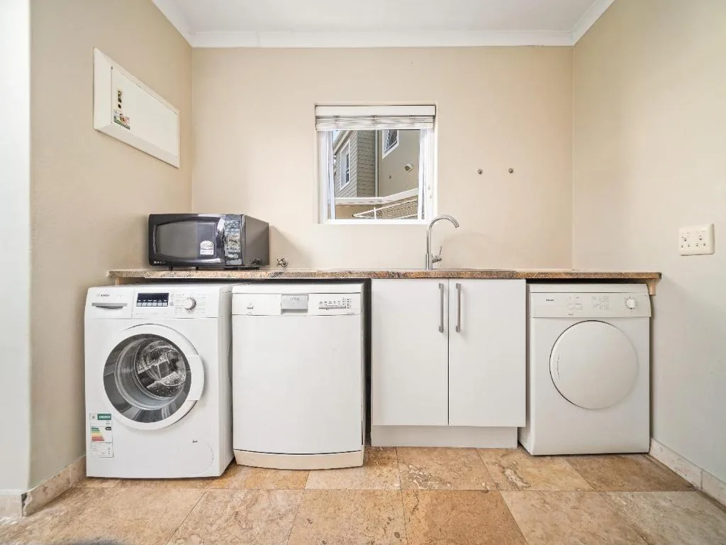 Laundry room with washing machine, dryer, and kitchen appliances