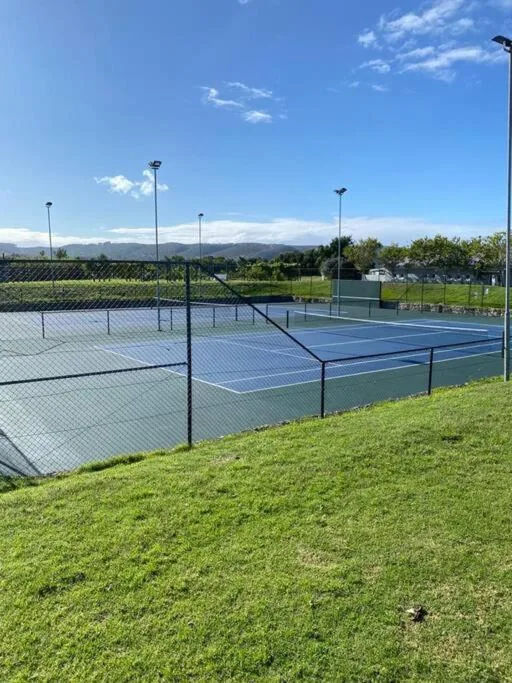 Professional tennis courts with mountain views and manicured green surrounds