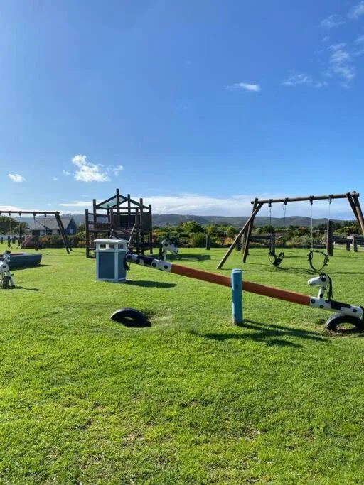 Open garden with equestrian jumps and training equipment on manicured lawn