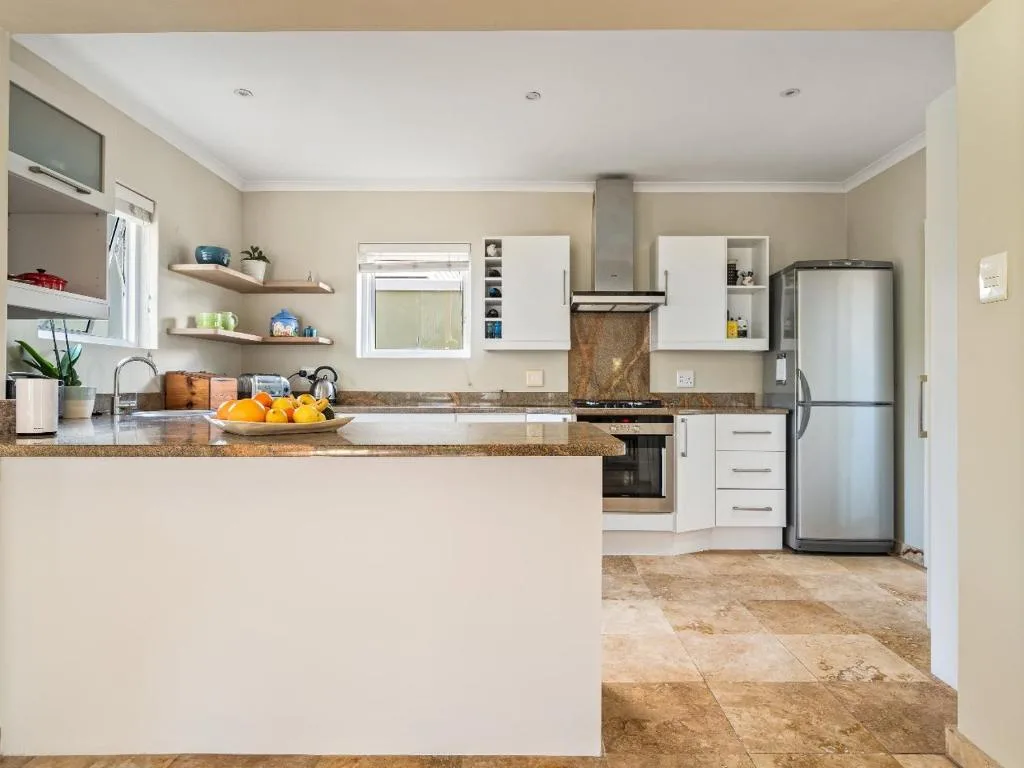 Modern kitchen with stainless steel appliances, granite countertops, and white cabinetry