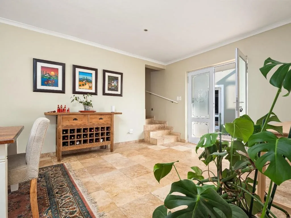 Bright living area with wooden wine cabinet and framed artwork on walls