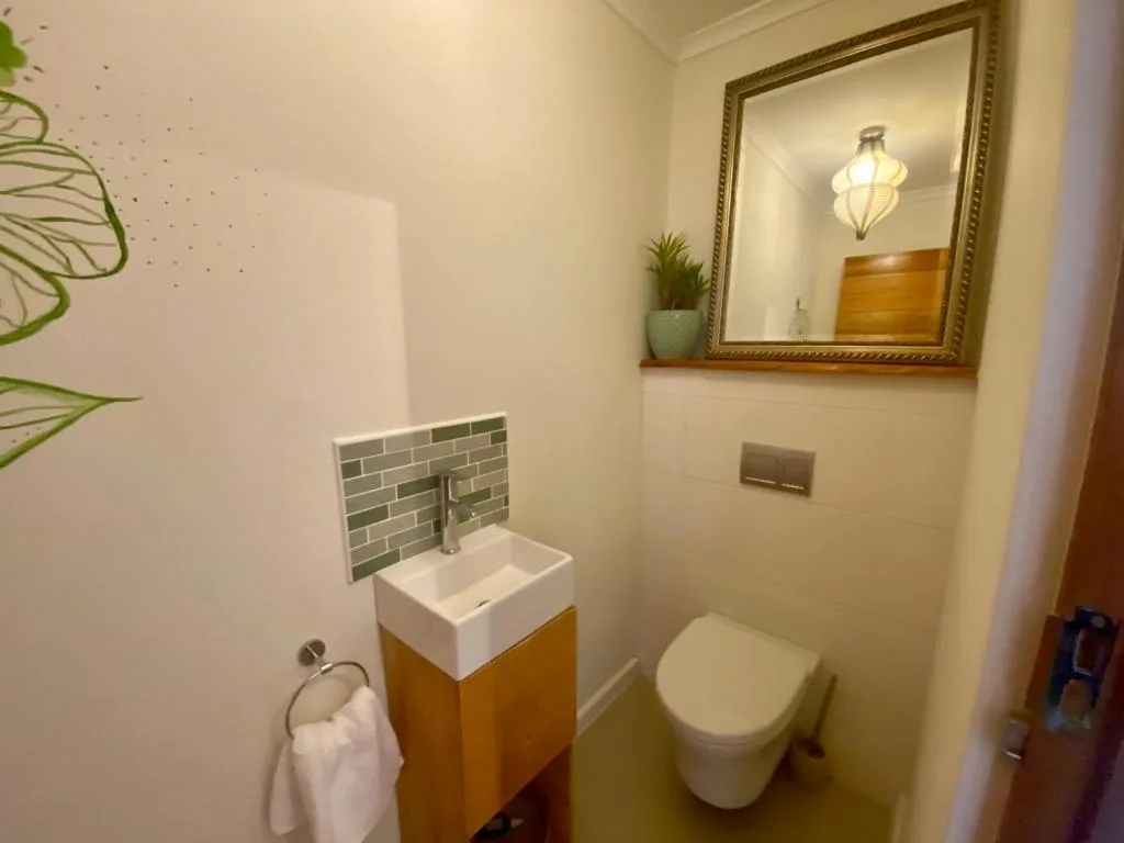 Modern bathroom with wall-mounted vanity, toilet, and framed mirror