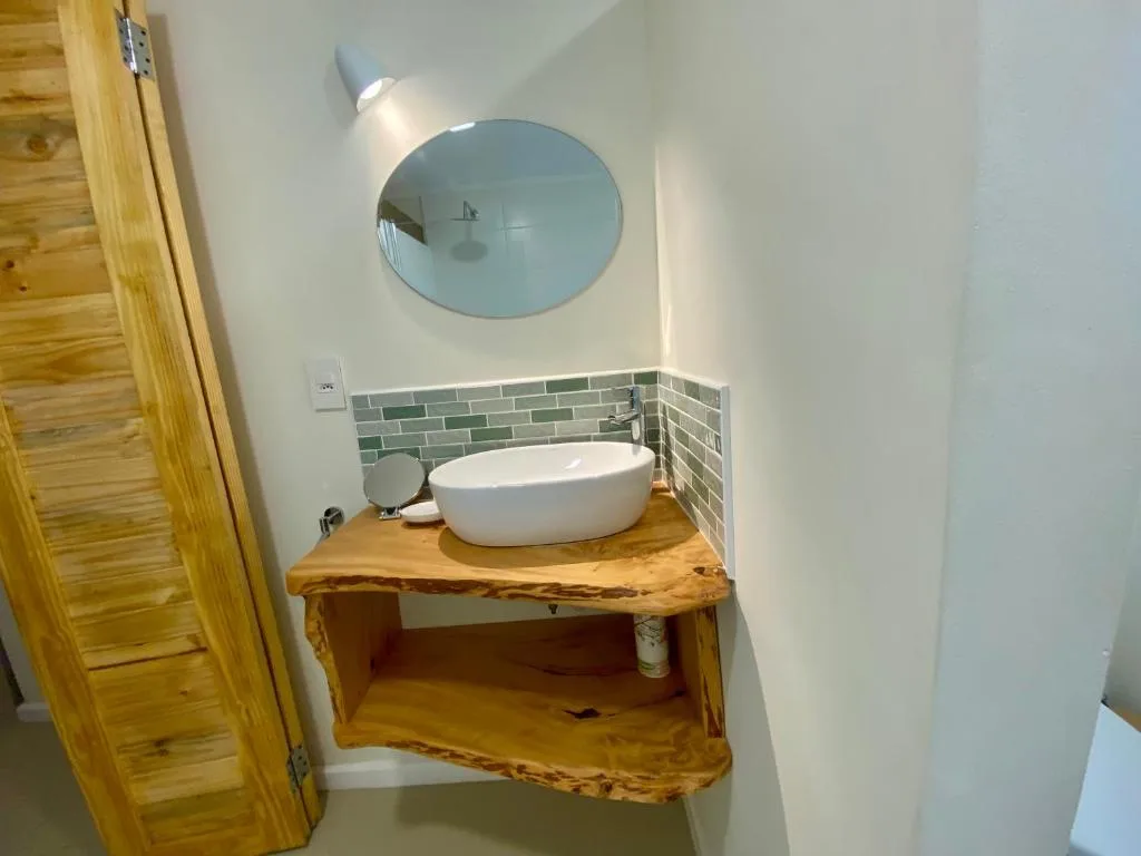 Modern bathroom vanity with round white basin and circular mirror above