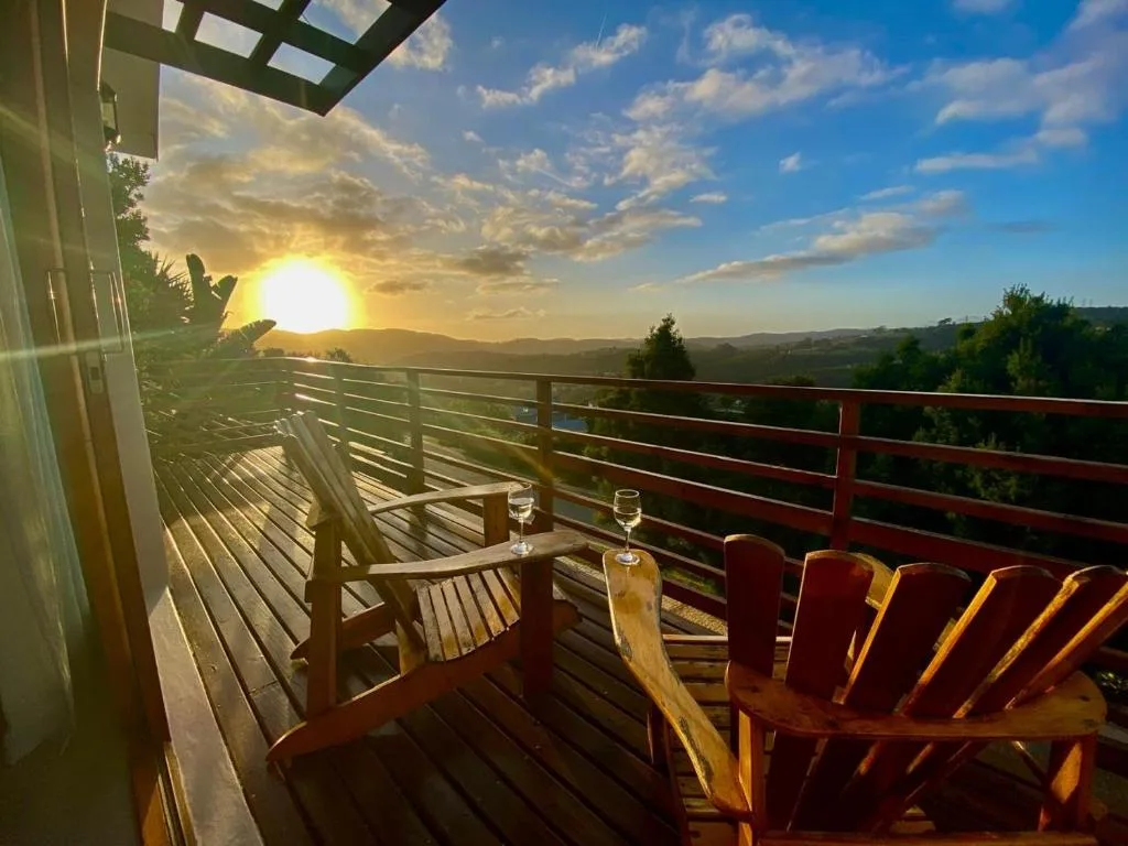 Wooden deck with chairs overlooking mountains at sunset, Garden Route