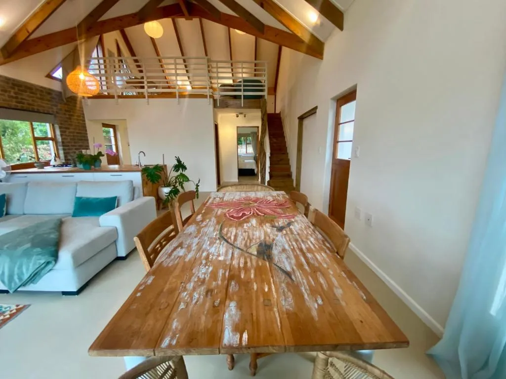 Spacious open-plan dining area with wooden table and exposed beam ceiling