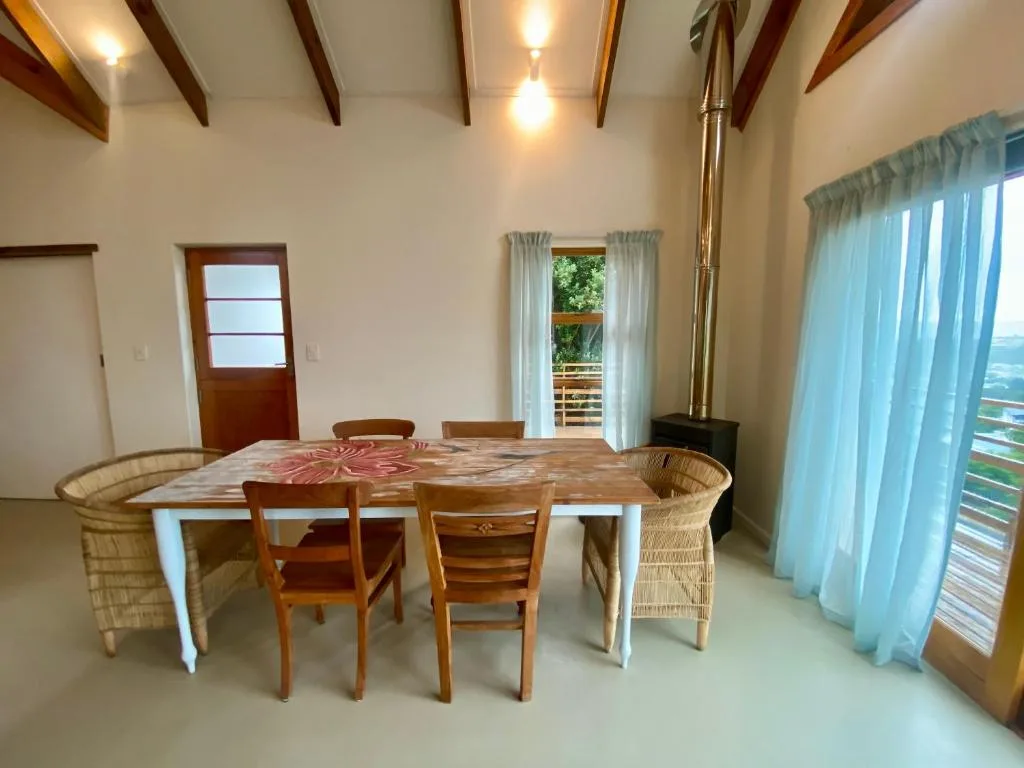 Spacious dining area with wooden table and woven chairs, ocean views